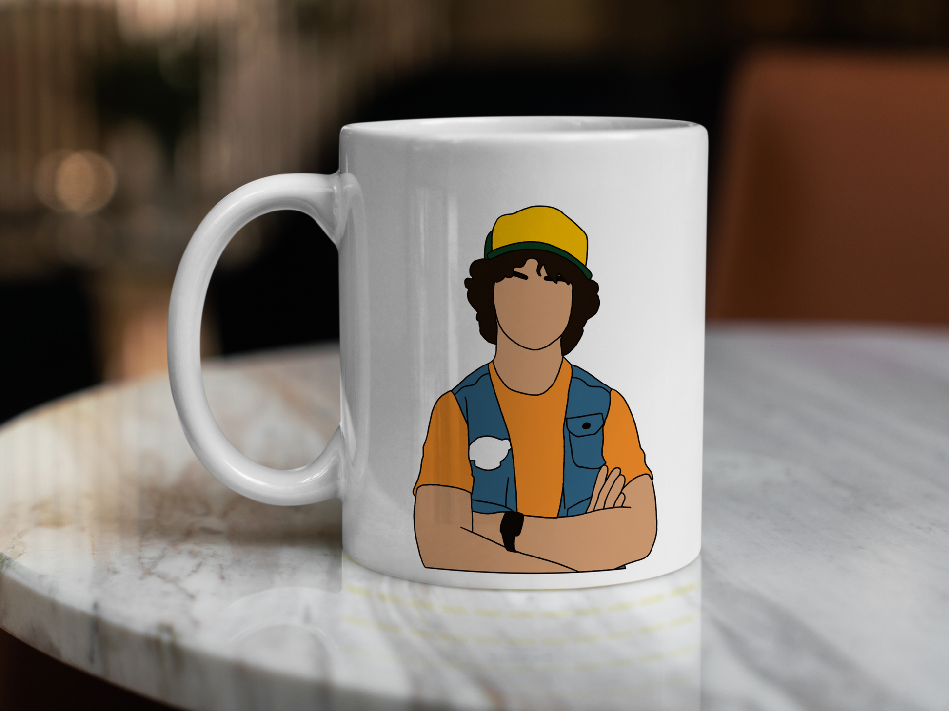 A white ceramic mug with a drawing of Dustin Henderson from Stranger Things on the front. This is a 10oz mug which is perfect for fans of Stranger Things, particularly the character Dustin Henderson. Made and sold by Krissi's Creations.