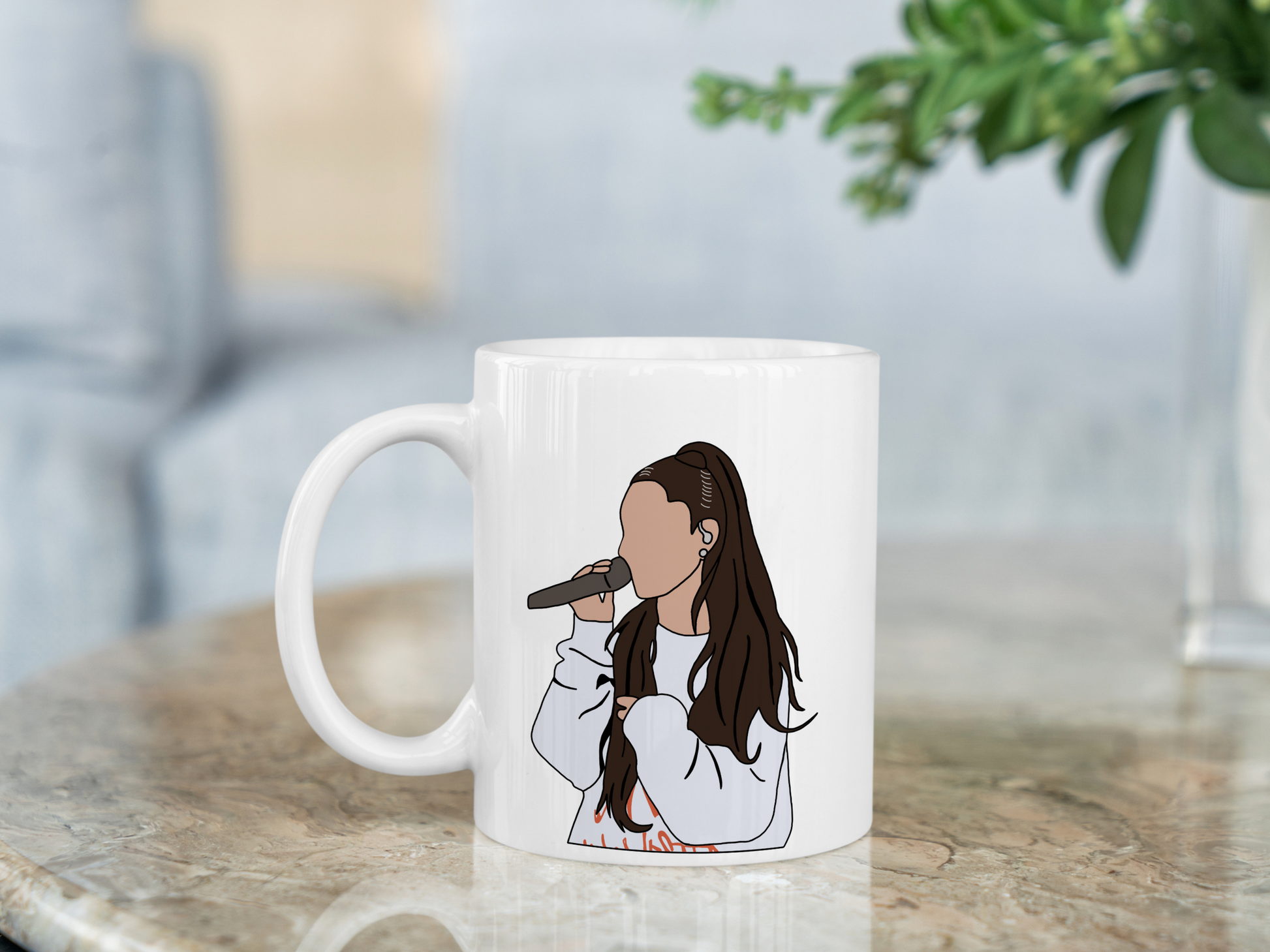 A white ceramic mug with a drawing of Ariana Grande on the front. This is a 10oz mug which is perfect for fans of Ariana Grande Concerts. Made and sold by Krissi's Creations.