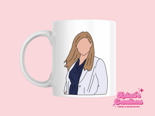 A white ceramic mug with a drawing of Arizona Robbins from Grey's Anatomy on the front. This is a 10oz mug which is perfect for fans of Grey's Anatomy, particularly the character Arizona Robbins. Made and sold by Krissi's Creations.