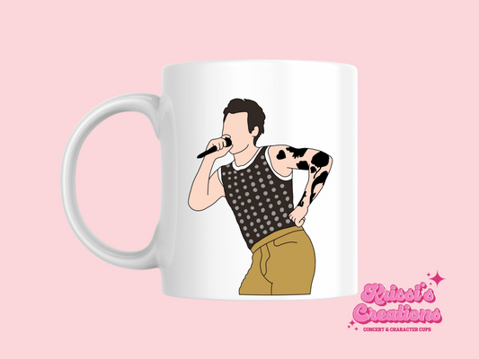 A white ceramic mug with a drawing of Harry Styles Cardiff Night 1 Outfit on the front. This is a 10oz mug which is perfect for fans of Harry Styles Love on Tour Concert. Made and sold by Krissi's Creations.