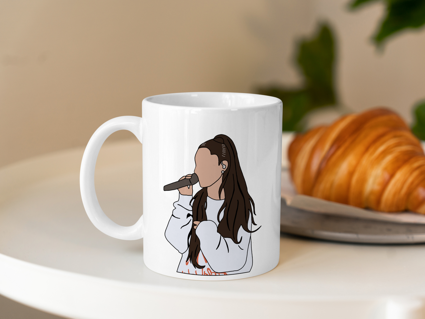 A white ceramic mug with a drawing of Ariana Grande on the front. This is a 10oz mug which is perfect for fans of Ariana Grande Concerts. Made and sold by Krissi's Creations.