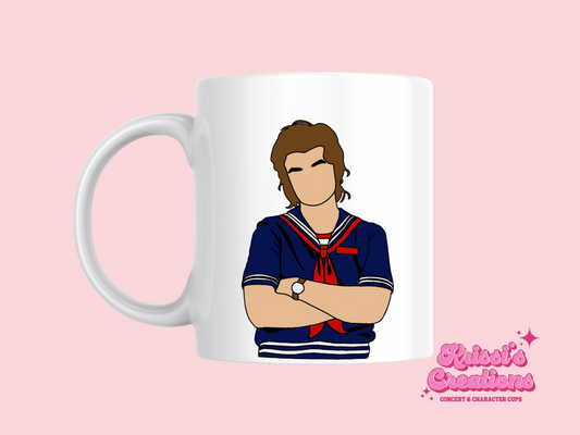 A white ceramic mug with a drawing of Steve Harrington from Stranger Things on the front. This is a 10oz mug which is perfect for fans of Stranger Things, particularly the character SteveHarrington. Made and sold by Krissi's Creations.