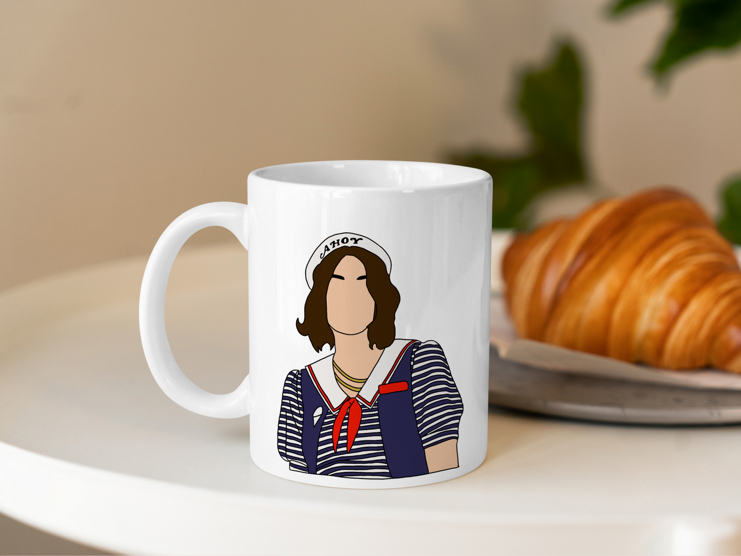 A white ceramic mug with a drawing of Robin Buckley from Stranger Things on the front. This is a 10oz mug which is perfect for fans of Stranger Things, particularly the character Robin Buckley. Made and sold by Krissi's Creations.