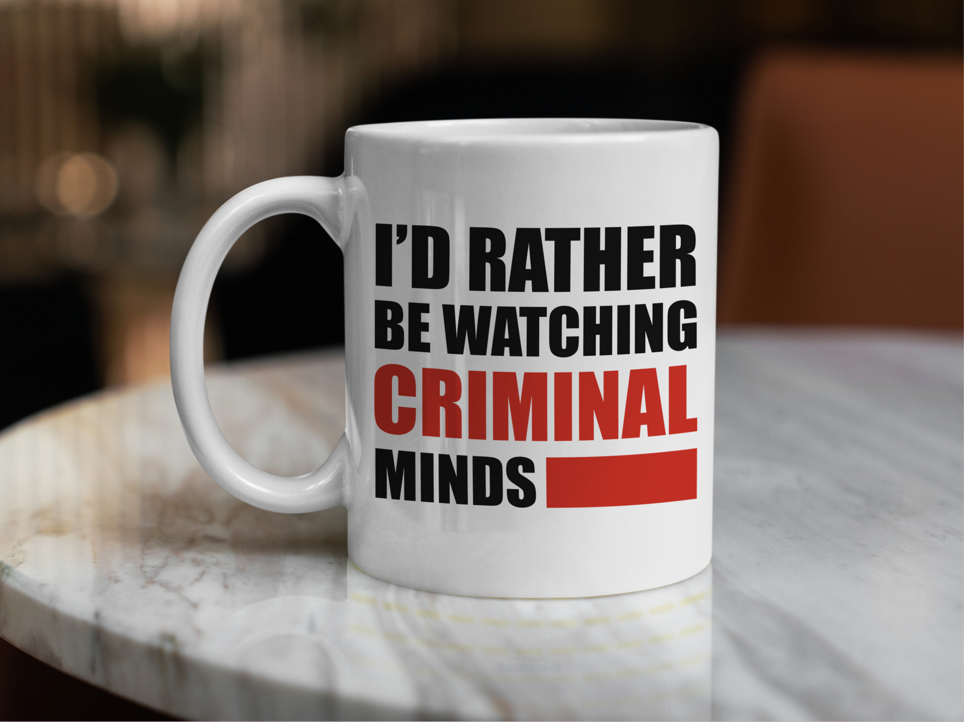 A white ceramic mug with the text I'd rather be watching Criminal Minds on the front. This is a 10oz mug which is perfect for fans of the series Criminal Minds. Made and sold by Krissi's Creations.