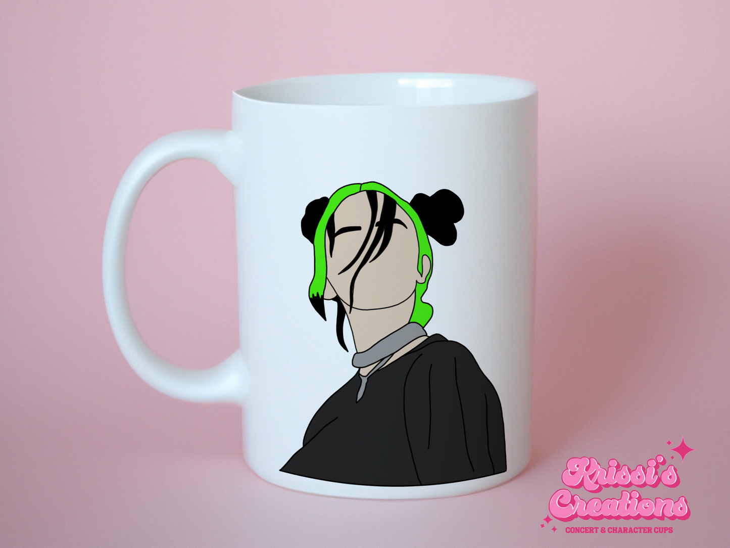 A white ceramic mug with a drawing of Billie Eilish with her Green and black hair on the front. This is a 10oz mug which is perfect for fans of Billie Eilish, particularly her Concerts. Made and sold by Krissi's Creations.