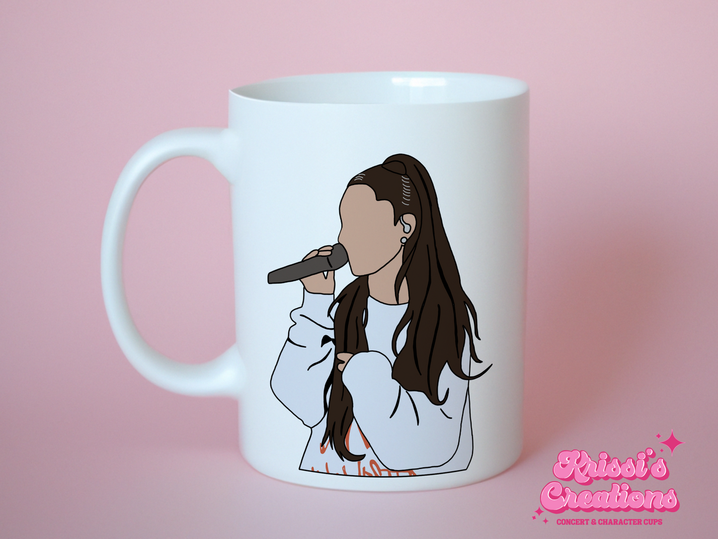 A white ceramic mug with a drawing of Ariana Grande on the front. This is a 10oz mug which is perfect for fans of Ariana Grande Concerts. Made and sold by Krissi's Creations.