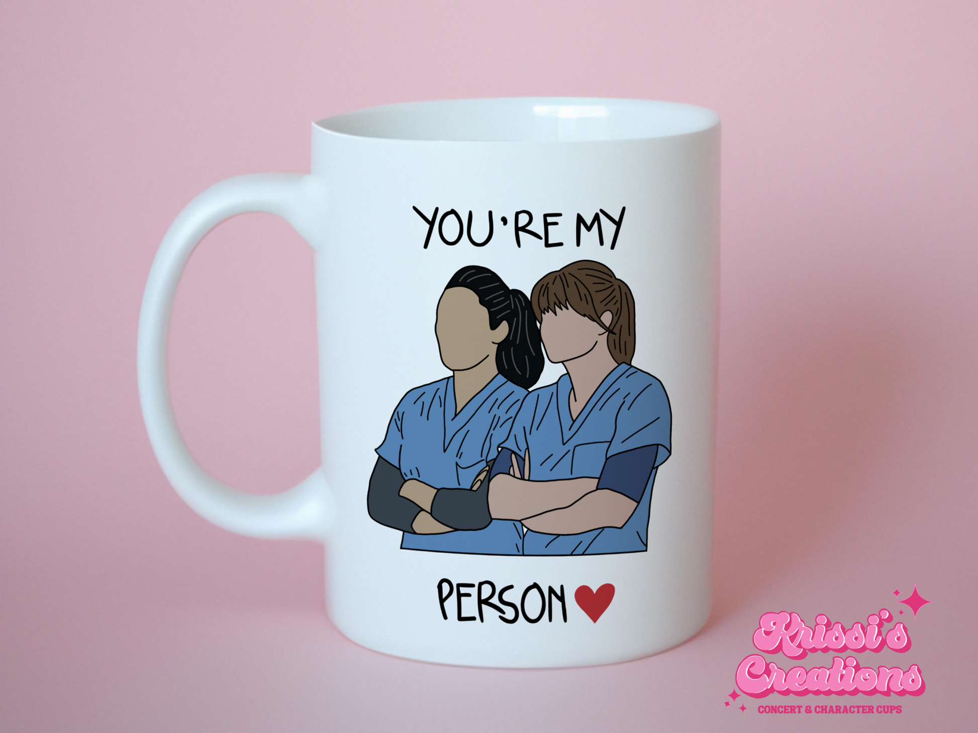 A white ceramic mug with a drawing of Meredith Grey and Cristina Yang from Grey's Anatomy on the front with the text You're my person. This is a 10oz mug which is perfect for fans of Grey's Anatomy, particularly the characters Meredith Grey and Cristina Yang. Made and sold by Krissi's Creations.