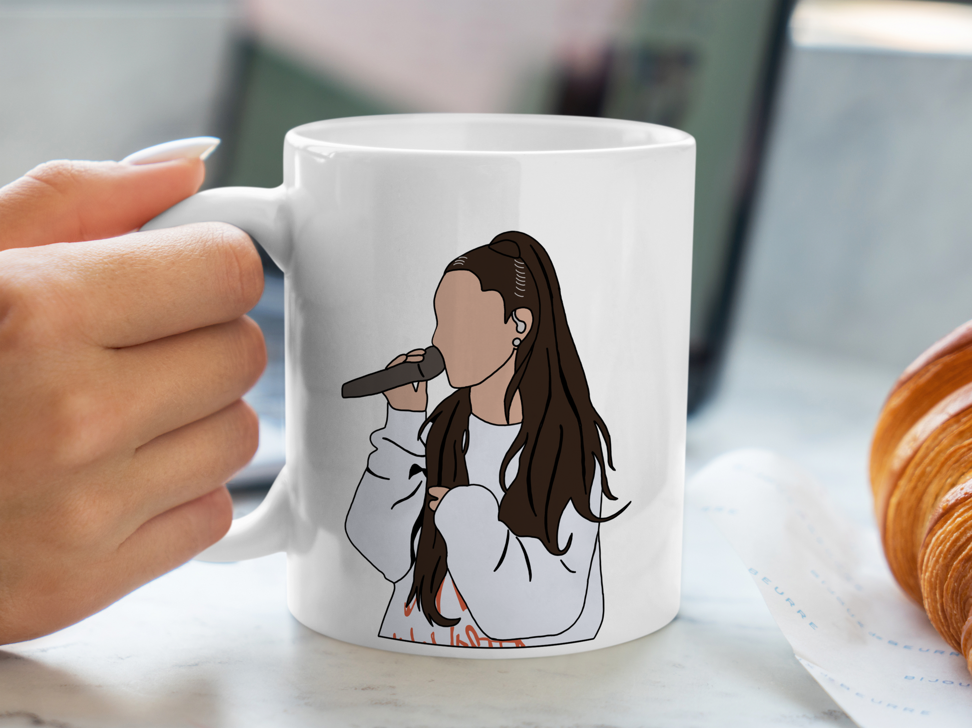 A white ceramic mug with a drawing of Ariana Grande on the front. This is a 10oz mug which is perfect for fans of Ariana Grande Concerts. Made and sold by Krissi's Creations.