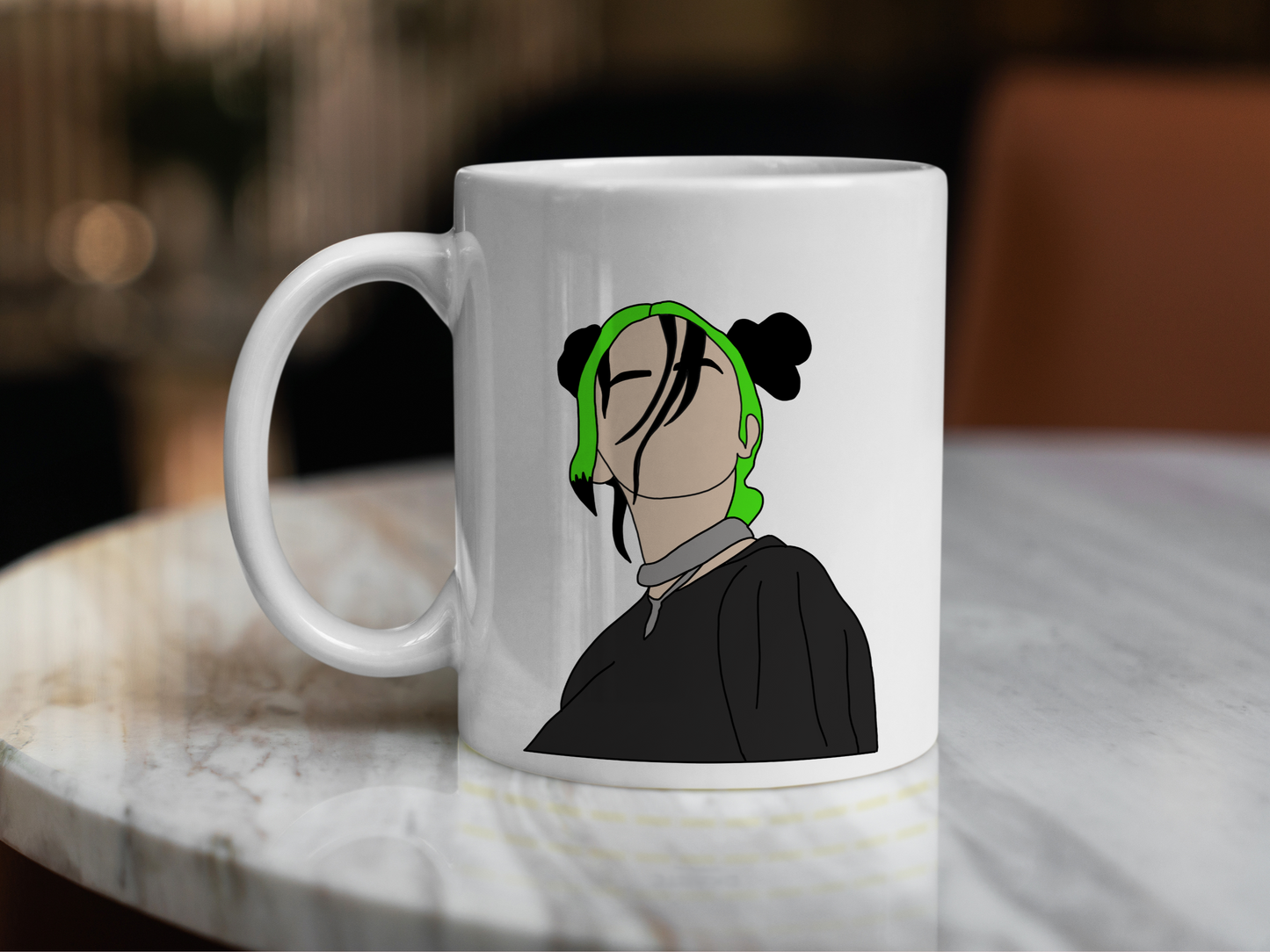 A white ceramic mug with a drawing of Billie Eilish with her Green and black hair on the front. This is a 10oz mug which is perfect for fans of Billie Eilish, particularly her Concerts. Made and sold by Krissi's Creations.