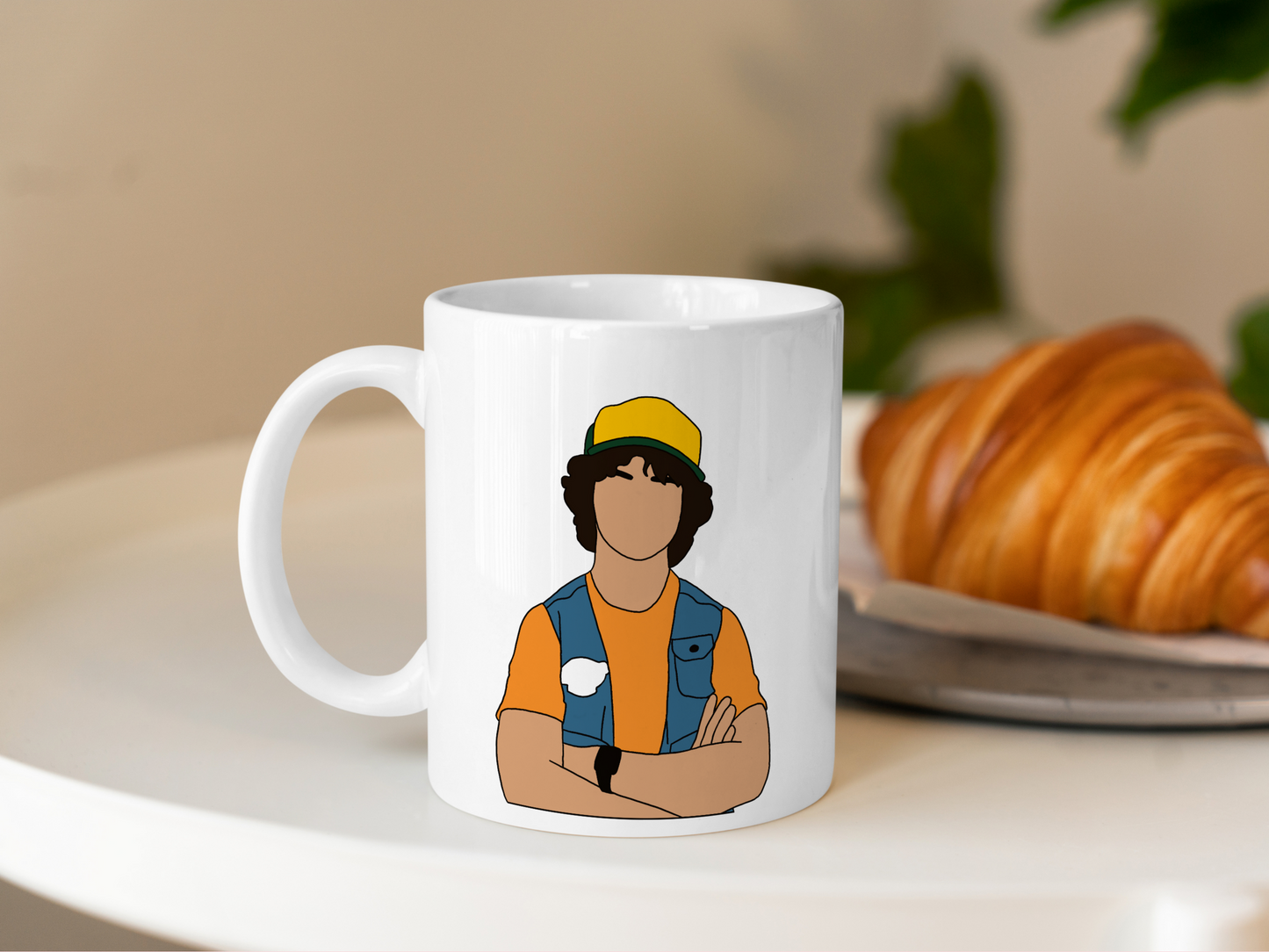 A white ceramic mug with a drawing of Dustin Henderson from Stranger Things on the front. This is a 10oz mug which is perfect for fans of Stranger Things, particularly the character Dustin Henderson. Made and sold by Krissi's Creations.