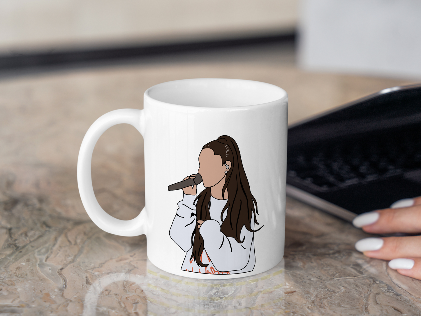 A white ceramic mug with a drawing of Ariana Grande on the front. This is a 10oz mug which is perfect for fans of Ariana Grande Concerts. Made and sold by Krissi's Creations.